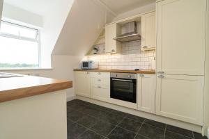 a kitchen with white cabinets and a counter top at Light airy 3 bed Town Cntr flat 700m to the Beach in Bournemouth