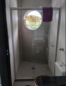 a bathroom with a shower with a window and a toilet at Hostap de frente com sacada in Porto Alegre