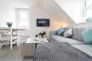 ein Wohnzimmer mit Sofa und Tisch in der Unterkunft Light airy 3 bed Town Cntr flat 700m to the Beach in Bournemouth