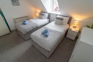 Deux lits dans une pièce avec deux animaux farcis bleus dans l'établissement Light airy 3 bed Town Cntr flat 700m to the Beach, à Bournemouth