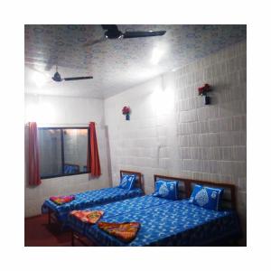 1 dormitorio con 2 camas y espejo en Jungle Homestay near Bandipur Mudumalai Masinagudi, en Mudumalai