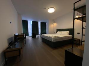 a bedroom with a bed and a desk and a mirror at HASS Boutique Hotel in Gostivar