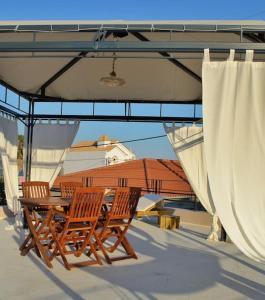 two chairs and a table on a patio with awning at Villa Hara, Lixouri, Kefalonia in Lixouri