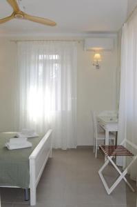 a white room with a bed and a table and a window at Villa Hara, Lixouri, Kefalonia in Lixouri