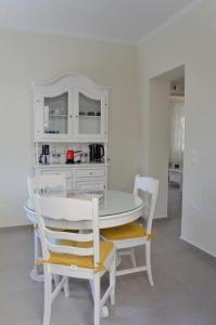 tavolo e sedie bianchi in una cucina bianca di Villa Hara, Lixouri, Kefalonia a Lixouri