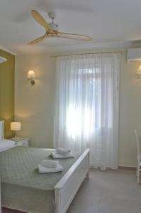 a bedroom with a bed and a ceiling fan at Villa Hara, Lixouri, Kefalonia in Lixouri