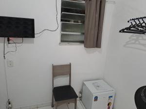 a room with a chair and a television and a refrigerator at Botafogo Guesthouse in Rio de Janeiro