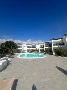 a swimming pool in front of a large building at Sea view with direct access to boulevard in Puerto del Carmen