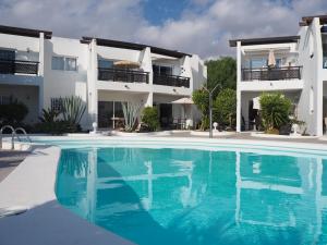 a villa with a swimming pool in front of a building at Sea view with direct access to boulevard in Puerto del Carmen