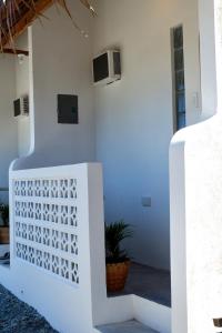 a white house with a white fence and a plant at Hiraya Baler Beachfront Cabanas in Baler