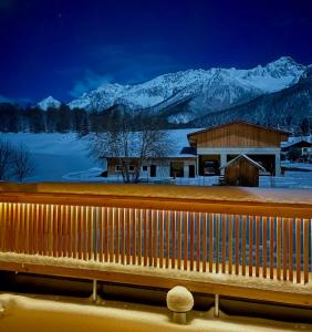 un edificio con montañas cubiertas de nieve en el fondo en Haus Sabine, en Leutasch