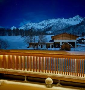 a building with snow covered mountains in the background at Haus Sabine in Leutasch