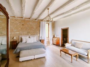 a bedroom with a bed and a couch and a chandelier at Moon River Grande Maison in Saint-Cyprien