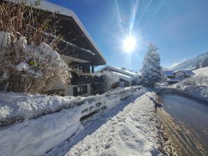 a snow covered road in front of a house at Alpenfee Ofterschwang mit E-Bike Garage in Ofterschwang