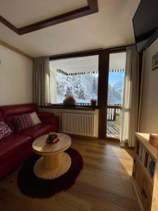 a living room with a red couch and a table at Home, sweet home in Livigno