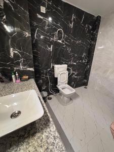 a bathroom with a white toilet and a sink at Inara Farms in Lucknow