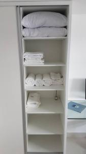 a closet filled with towels and a stack of towels at Aconchegante Apartamento Beira-Mar (Ampla Varanda) in João Pessoa