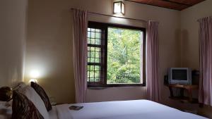 Royal Mist Munnar في Anachal: غرفة نوم بسرير ونافذة