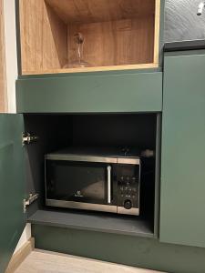 a microwave in a cabinet in a kitchen at Tammemäe Spa Lodge 