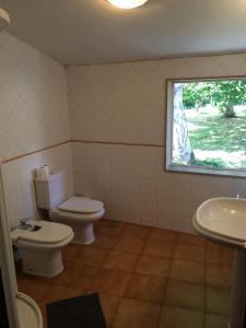 a bathroom with a toilet and a sink and a window at Pensión de Logrosa in Negreira +40 photos