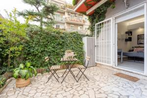 un patio con una puerta blanca y un seto verde en Holiday Homes Rome - Portuense 21 - Studio with little private Garden, en Roma
