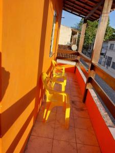 a row of yellow chairs sitting on a balcony at casa grande e tranquila in Porto Seguro