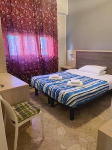 una camera da letto con un letto e due asciugamani di HOTEL BISSI a Milano
