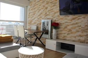 a living room with a table and chairs and a brick wall at Appart T3 kodjo in Pessac