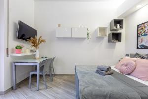 sala de estar con mesa, cama y escritorio en Holiday Homes Rome - Portuense 21 - Studio with little private Garden, en Roma