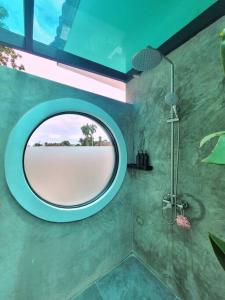 a bathroom with a round mirror and a shower at Villa Coco in Thalang