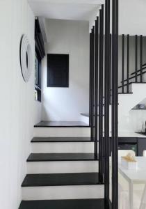 a hallway with black and white stairs in a house at Villa Coco in Thalang