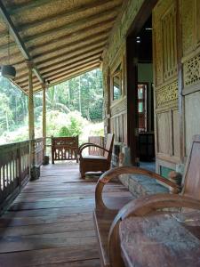 a porch of a house with benches on it at duegoal farmhouse in Jatiluwih