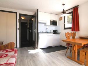 eine Küche und ein Esszimmer mit einem Tisch und einem Esszimmer in der Unterkunft Appartement Huez, 1 pièce, 4 personnes - FR-1-405-108 in L'Alpe-d'Huez