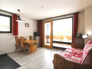 a bedroom with a table and a room with a balcony at Appartement Huez, 1 pièce, 4 personnes - FR-1-405-108 in L'Alpe-d'Huez