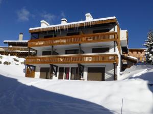 un edificio con nieve delante en Appartement Huez, 1 pièce, 4 personnes - FR-1-405-108 en L'Alpe-d'Huez