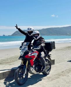 duas pessoas a andar de moto na praia em Hiraya Baler Beachfront Cabanas em Baler