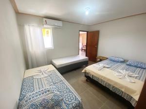 - une chambre avec 2 lits et une fenêtre dans l'établissement Casa Morada da Praia 1, à Peroba