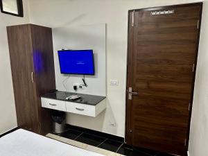 a bedroom with a television and a door with a desk at grover international in Bathinda