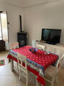 ein Esszimmer mit einem Tisch und einem TV in der Unterkunft A due passi dalle bellezze della Puglia in Sava