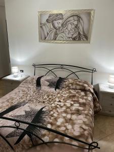 Schlafzimmer mit einem Bett mit Wandgemälde in der Unterkunft A due passi dalle bellezze della Puglia in Sava