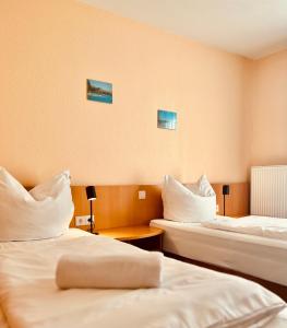 a room with two beds with white pillows at TM Hotel Westfalen in Lünen