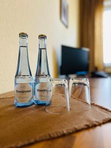 two bottles and two glasses sitting on a table at TM Hotel Westfalen in Lünen