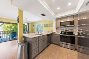 een keuken met grijze kasten en een fornuis met oven bij Beach Villa 2 Bedroom in Clearwater Beach +43 foto's