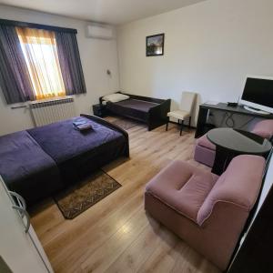 Habitación con cama, escritorio y sofá. en Guesthouse Kod mosta, en Karlovac