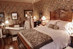 een slaapkamer met een bed en een bad en een bad bij The Queen, A Victorian Bed & Breakfast in Bellefonte