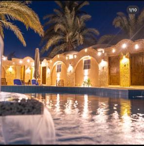 a house with a swimming pool at night at Siwa Palace Lodge in Siwa