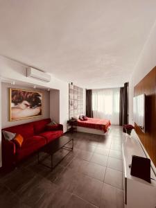 salon z czerwoną kanapą i łóżkiem w obiekcie Estudio junto La Nogalera 1 w mieście Torremolinos
