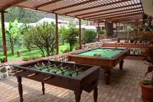 um pátio com uma mesa de bilhar e um pavilhão em Hostería Estancia el Angel em Gualaceo