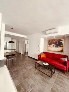 salon z czerwoną kanapą i stołem w obiekcie Estudio junto La Nogalera 1 w mieście Torremolinos