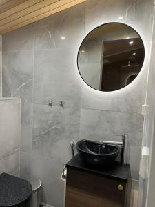 La salle de bains est pourvue d'un lavabo et d'un miroir. dans l'établissement Villa Auroras Karhu, à Syöte